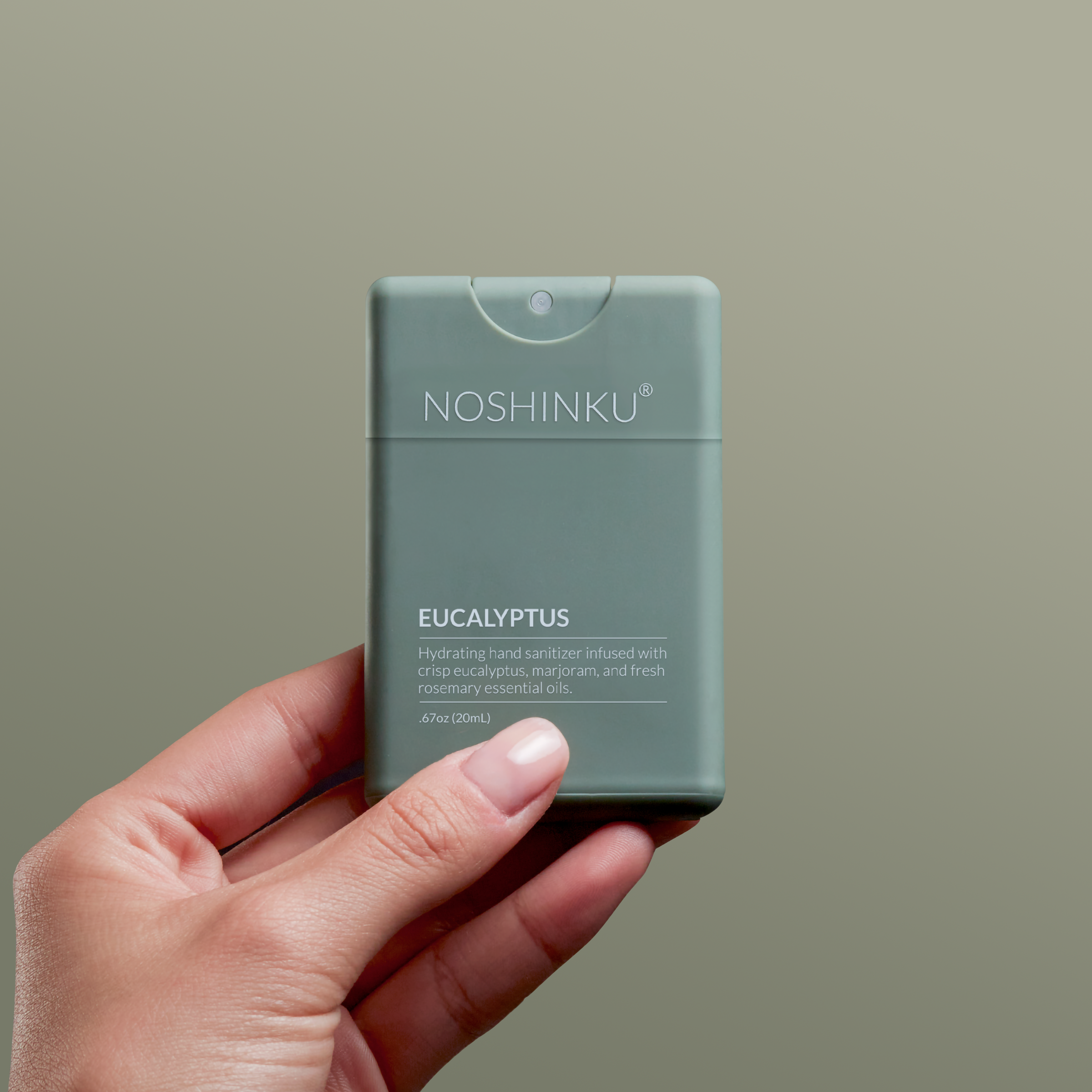 Hand holding a Noshinku Eucalyptus Hydrating refillable pocket hand sanitizer against a plain background