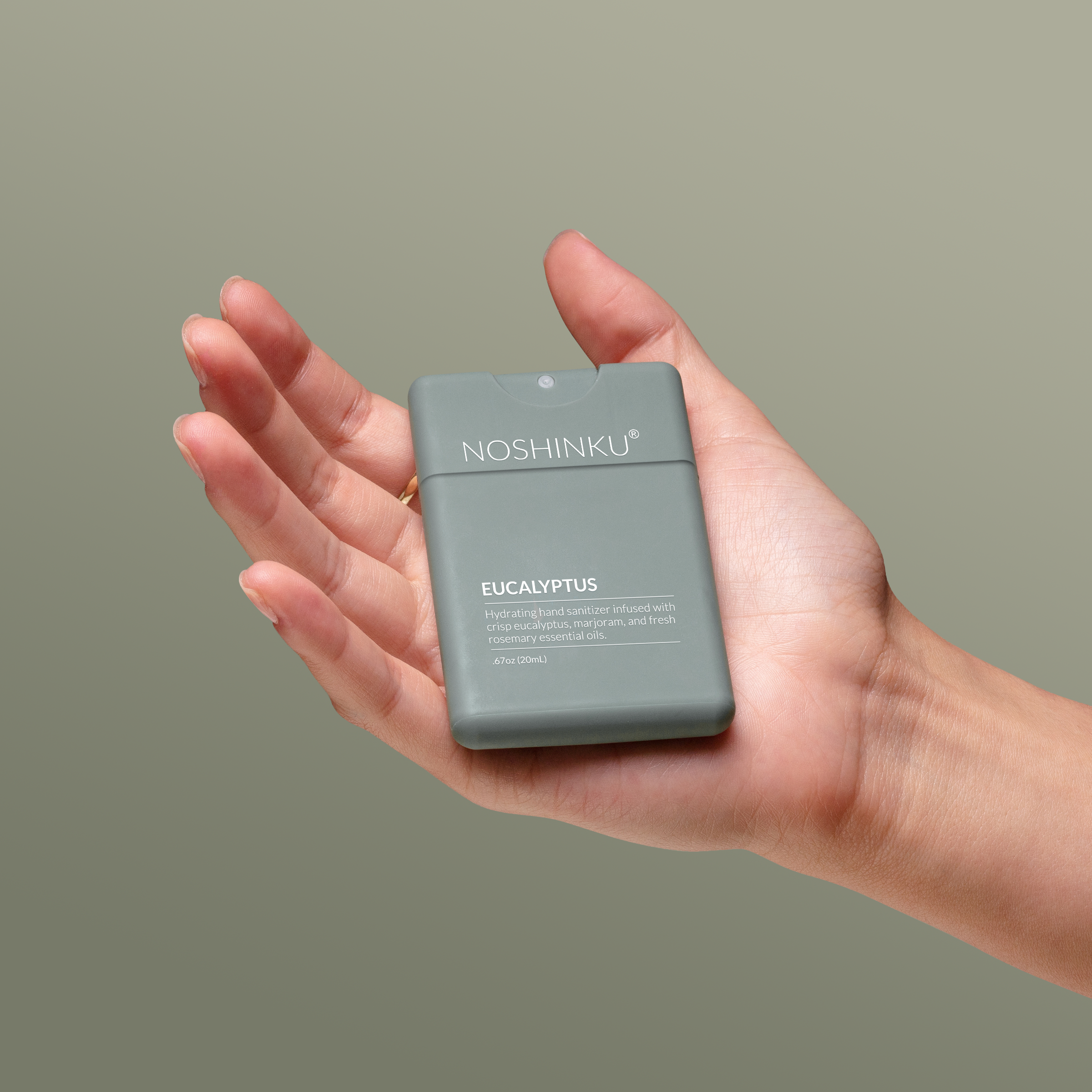 Hand holding Noshinku Eucalyptus Hydrating Pocket Hand Sanitizer Sprayer
